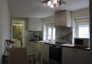 雅典The Ellinikon - Metro Apartment的厨房配有桌子、水槽和微波炉