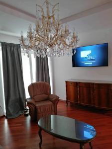 斯洛文尼亚比斯特里察Apartma Bistrica的客厅配有吊灯、桌子和椅子