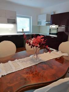 斯洛文尼亚比斯特里察Apartma Bistrica的厨房配有一张桌子,上面放着花瓶