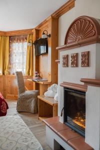 摩德纳迪-坎皮格里奥吉安娜酒店的客厅设有壁炉和椅子