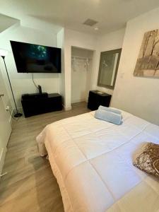 迈阿密Quiet & Centrally located House的卧室配有一张白色大床和一台平面电视。