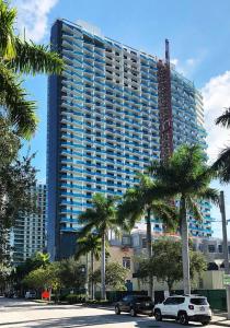 迈阿密Quiet & Centrally located House的一座棕榈树环绕的大建筑