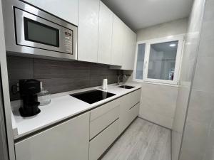 巴利亚多利德Apartamento en pleno centro de Valladolid的厨房配有白色橱柜和微波炉