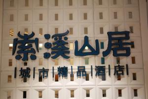 张家界Zhangjiajie lollipop Hotel的白色建筑上写有中国文字的标志