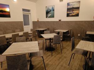 布拉格哲拉塔瓦哈酒店的餐厅设有桌椅,墙上挂有绘画作品