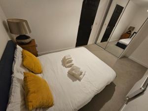 斯代普斯Superb 3 Bed Home Away from Home in Glasgow, just off M8 with free parking的一间卧室配有一张带黄色枕头和镜子的床