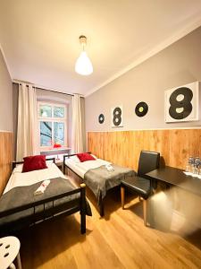 波兹南Explorer Hostel & Apartment Stare Miasto OLD TOWN 24H的酒店客房配有两张床和一张书桌