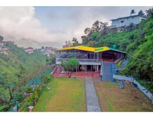 穆索里Shiv Sutra Resorts, Mussoorie的山坡上一座黄色屋顶的建筑