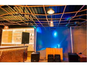 穆索里Shiv Sutra Resorts, Mussoorie的一间设有蓝屏和桌子的舞台的房间