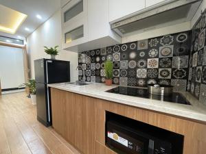 河内Funhome Apartment Kim Ma Ha Noi的厨房配有炉灶和冰箱。