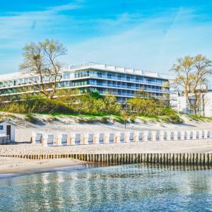 科沃布热格Seaside Park Hotel的海滩上的一座建筑,靠近一片水域