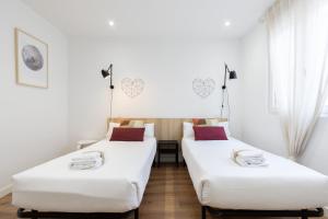 帕伦西亚INSIDEHOME Apartments - La Casita de Oscar的白色墙壁客房的两张床
