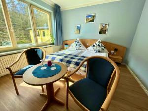 奎德林堡哈茨家庭俱乐部假日公园的卧室配有一张床和一张桌子及椅子