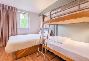 万泽内姆B&B HOTEL Colmar Vignobles Ouest的带窗户的客房内的两张双层床