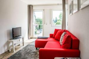 塞利根斯塔特Schönes Haus mit großem Garten的带电视的客厅内的红色沙发