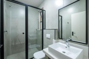 约翰内斯堡Inn & Out Plus Rosebank的白色的浴室设有水槽和淋浴。