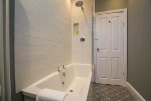 霍伊莱克Fairways View - Spacious Apartment - Sleeps 6 - Lovely Views的白色的浴室设有浴缸和淋浴。