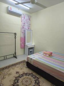 MacangWafiy Homestay的一间卧室配有一张床和一台电视。