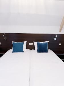 霍恩磁铁酒店的两张带蓝色枕头的床铺,彼此相邻