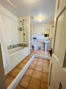 卡斯尔顿Peak Hotel Castleton的带浴缸、卫生间和盥洗盆的浴室