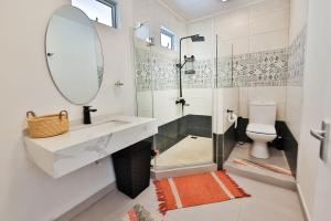 蒙舒瓦西OceanBreeze Apartments Mont Choisy的带淋浴、盥洗盆和镜子的浴室