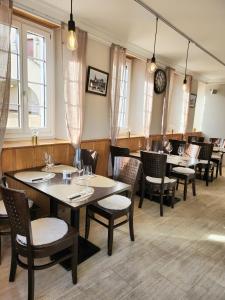 朗斯Auberge de l’Union的餐厅设有桌椅和墙上的时钟