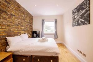 伦敦Bright and Quiet 2-bed 2-bath with Great Patio的一间卧室设有砖墙和一张床