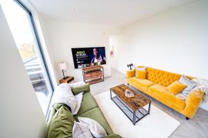 利兹Luxurious 4-Bedroom Penthouse: 15 Mins to City Centre, Secure Parking的客厅配有黄色的沙发和桌子