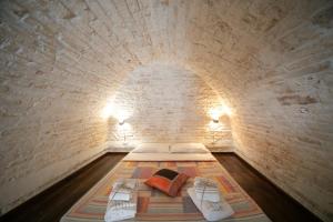 阿尔贝罗贝洛Trulli di Nonno Carlo的小房间,砖墙里设有一张床铺