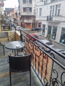 巴统MAHALI HOTEL的阳台配有桌椅和街道。