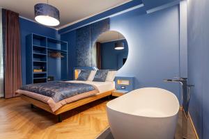 米兰Le Texture Premium Rooms Duomo-Cordusio的一间蓝色卧室,配有床和圆镜子