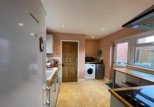 雷克瑟姆Merlin House的厨房配有洗衣机和烘干机