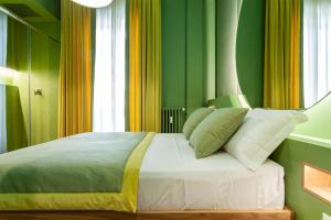 米兰Le Texture Premium Rooms Duomo-Cordusio的一间卧室设有一张带绿色和黄色墙壁的床。