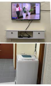 MacangWafiy Homestay的书桌上配有电视和洗衣机