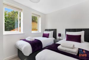 达特福德OnSiteStays - Contemporary 2 Bed Apt with Ensuite, 2 x Free Parking Spaces & a Balcony的白色客房的两张床,设有两扇窗户