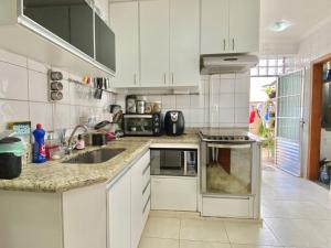 贝洛奥里藏特Portal do Jaragua的厨房配有白色橱柜和水槽