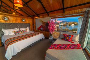 普诺KAY PACHA LODGE lago titicaca All Inclusive的一间卧室设有床、窗户和沙发
