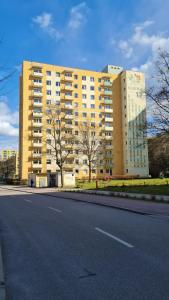 索波特Apartament z widokiem na las的道路一侧的黄色大建筑