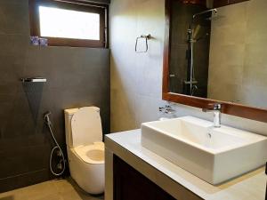 米迪加马东Coastal Hideaway的一间带水槽、卫生间和镜子的浴室