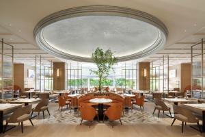 东京东京威斯汀酒店的一间带桌椅和大型天花板的餐厅