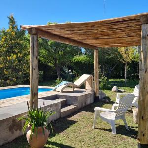 Los ÁrbolesEspacio Nux的后院设有木制凉棚、椅子和游泳池
