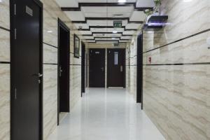 迪拜Glamorous Partition Room in Barsha 1 Near Metro的建筑中一个空的走廊,有黑色的门