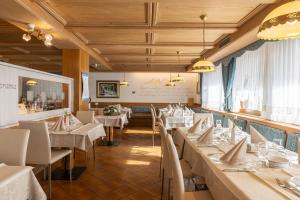 圣马蒂诺-迪卡斯特罗扎Hotel Panorama的用餐室配有白色的桌子和白色的椅子
