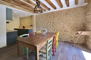 Les MolièresLe Gîte - Le Pressoir的厨房以及带木桌和椅子的用餐室。