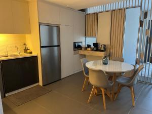 安曼DAMAC Luxury new 1 bedroom apartment的一间带桌子和冰箱的小厨房