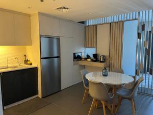 安曼DAMAC Luxury new 1 bedroom apartment的一间带桌子和冰箱的小厨房