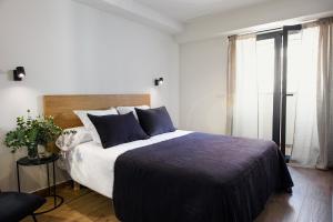 阿利坎特Apartamento Bguest的一间卧室配有一张带蓝色枕头的大床