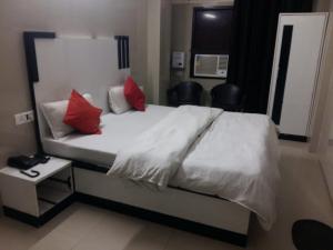 哈里瓦Hotel Shiva Palace haridwar nearby bus and railway station的卧室配有带红色枕头的白色床