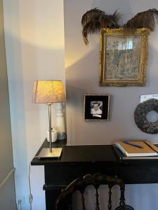 豪达海尔纳斯特之家住宿加早餐旅馆的一张桌子,上面有台灯和墙上的照片