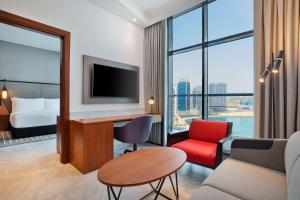 迪拜The First Collection Waterfront的酒店客房设有一张床和一张带电视的书桌。
